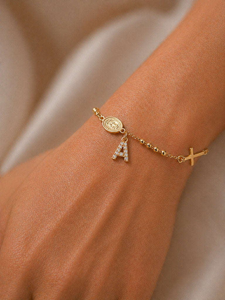 Close-up of Virgin Mary and cross charm in gold - Calioras