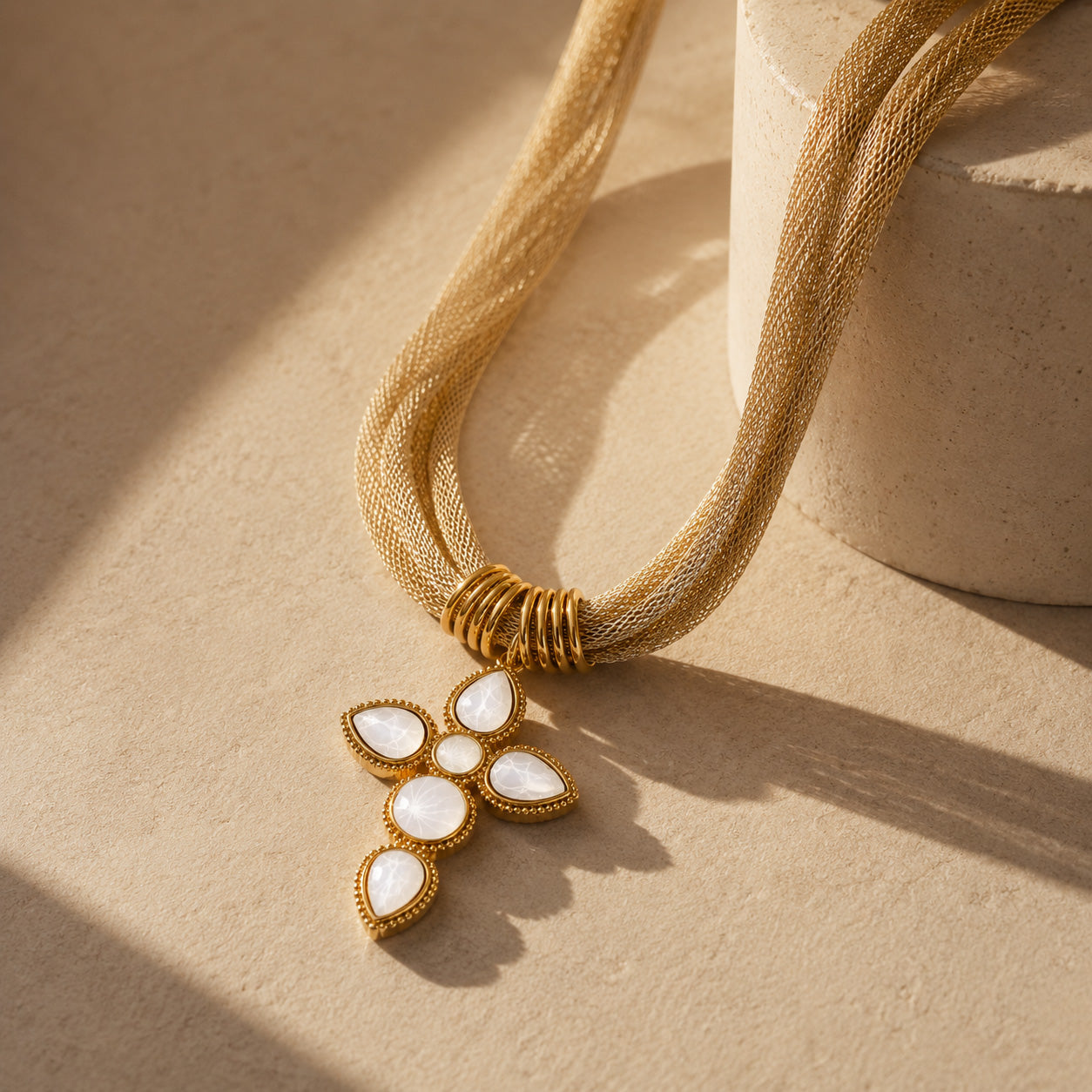 Vintage mesh white cross necklace styled on cream still life