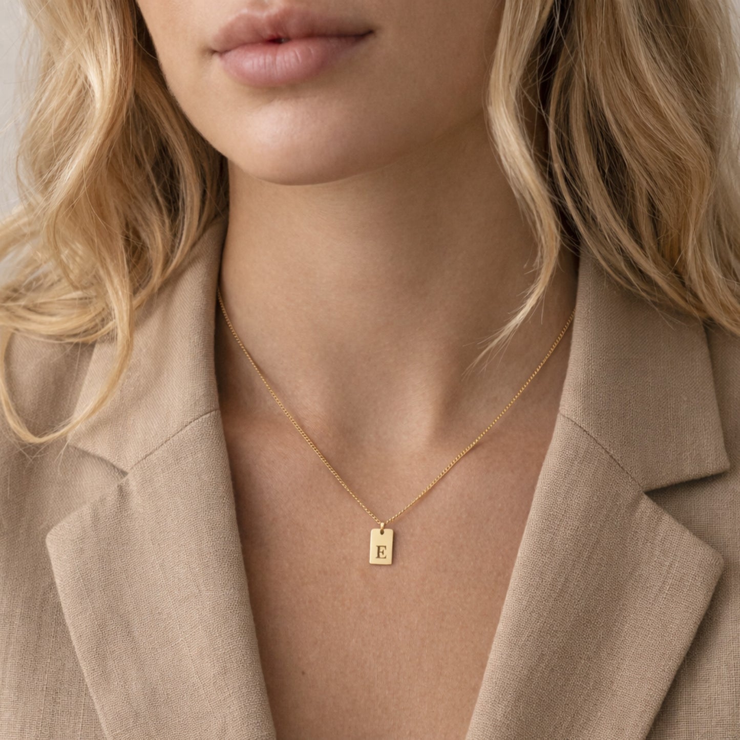 Woman wearing gold initial tag necklace - Calioras