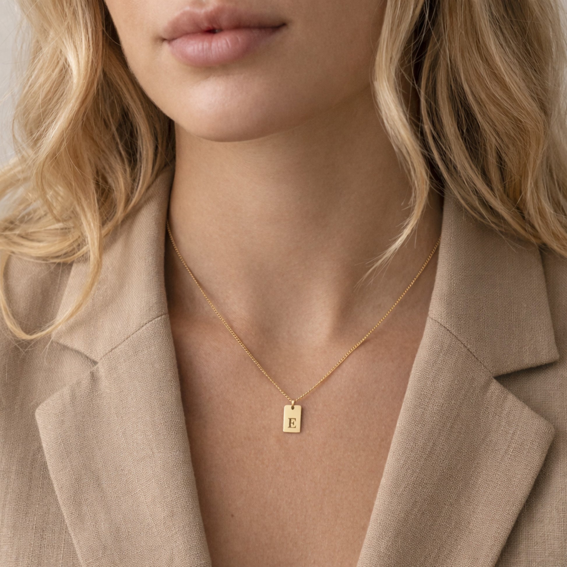 Woman wearing gold initial tag necklace - Calioras