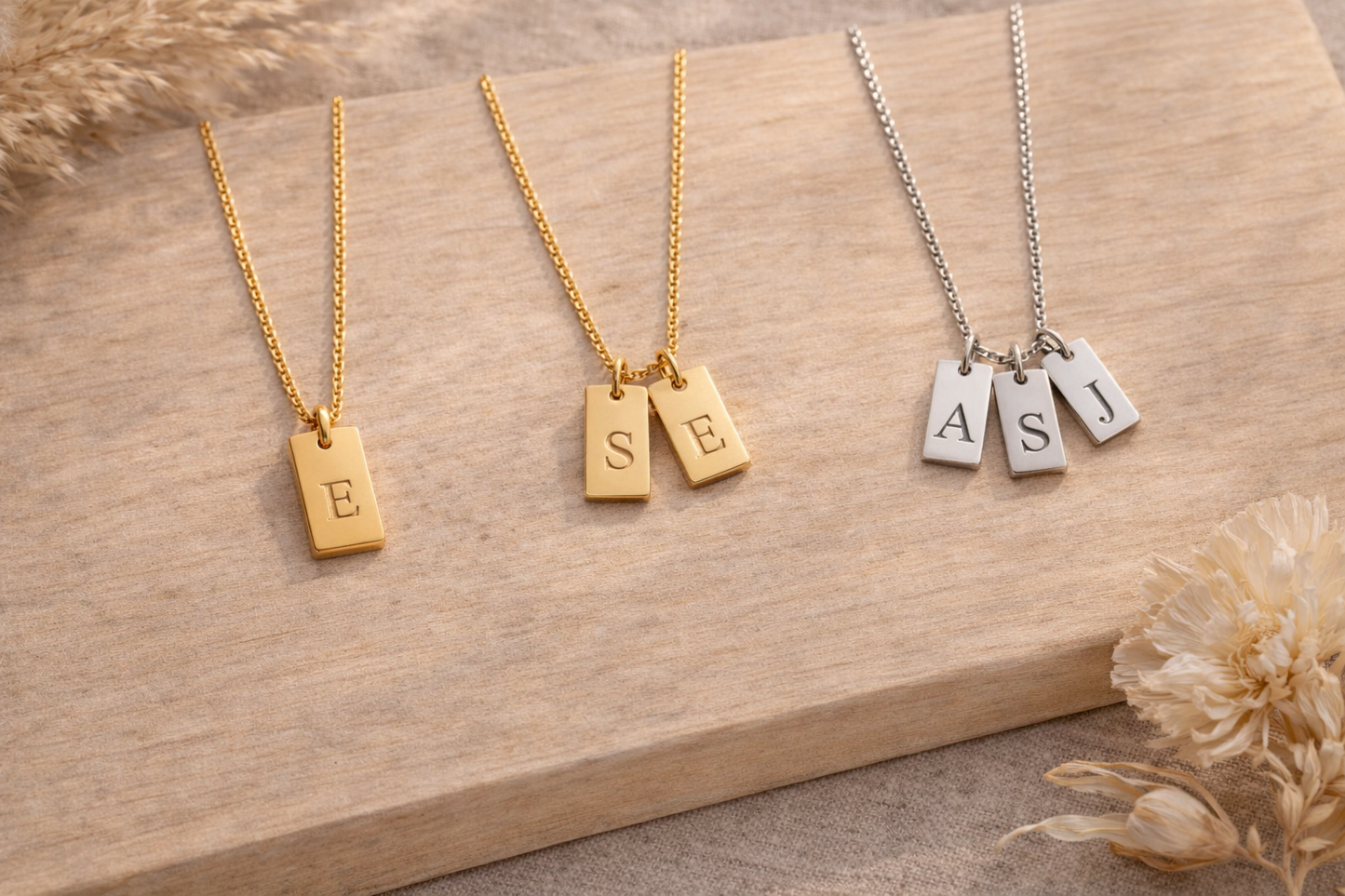 Close-up of engraved initial tag pendant in gold - Calioras