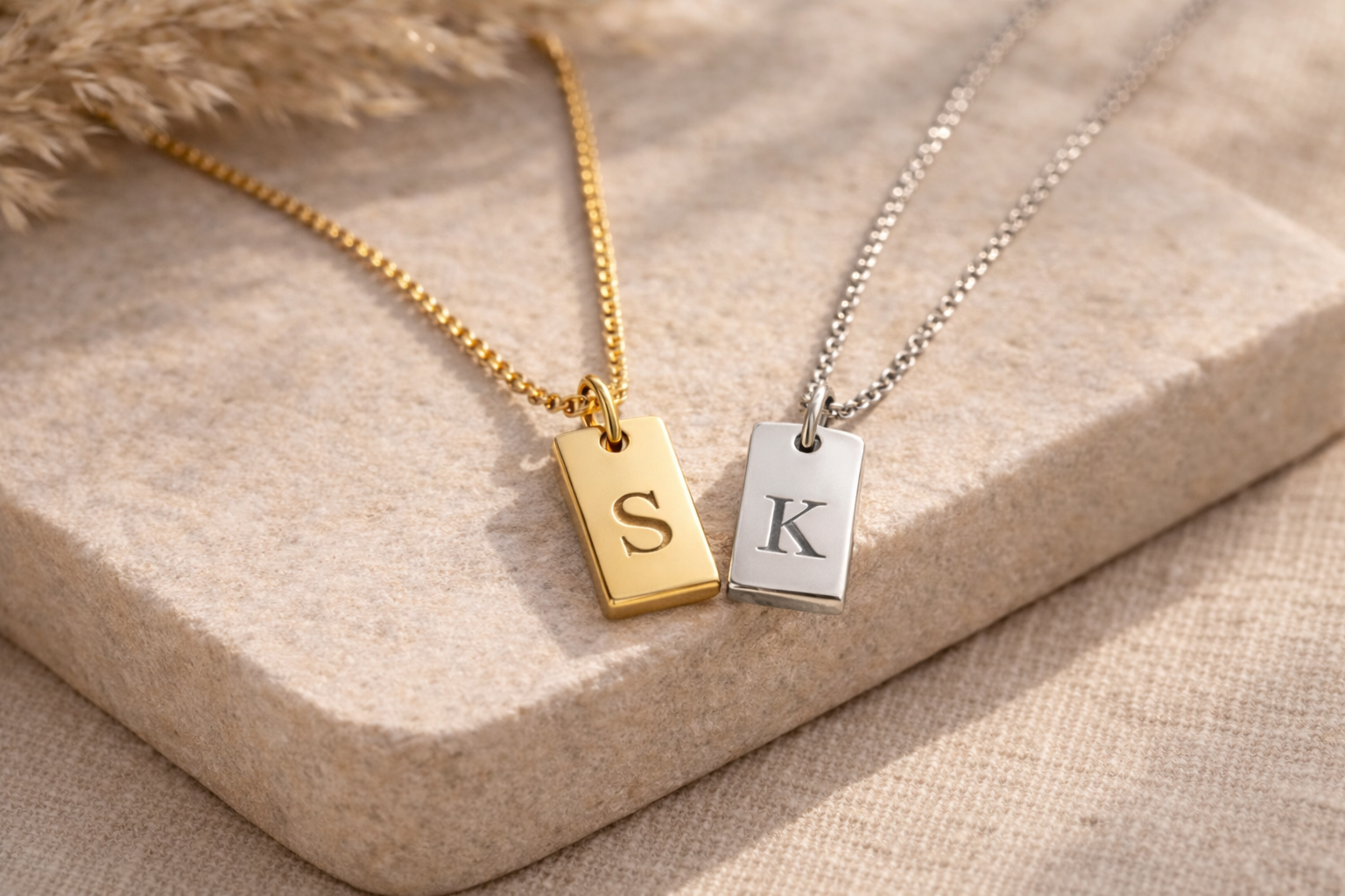 Close-up of engraved initial tag pendant in gold - Calioras
