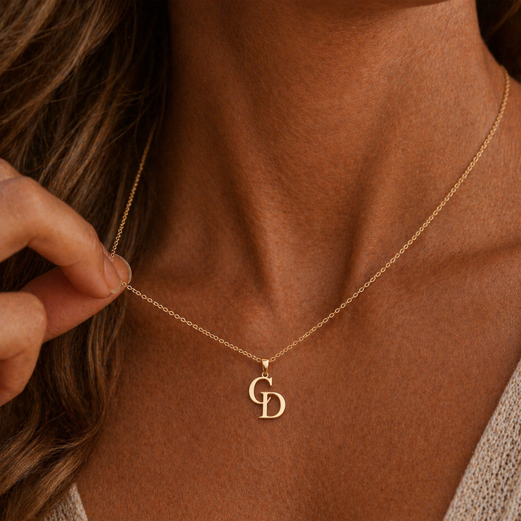 Close-up of intertwined initial pendant in gold - Calioras
