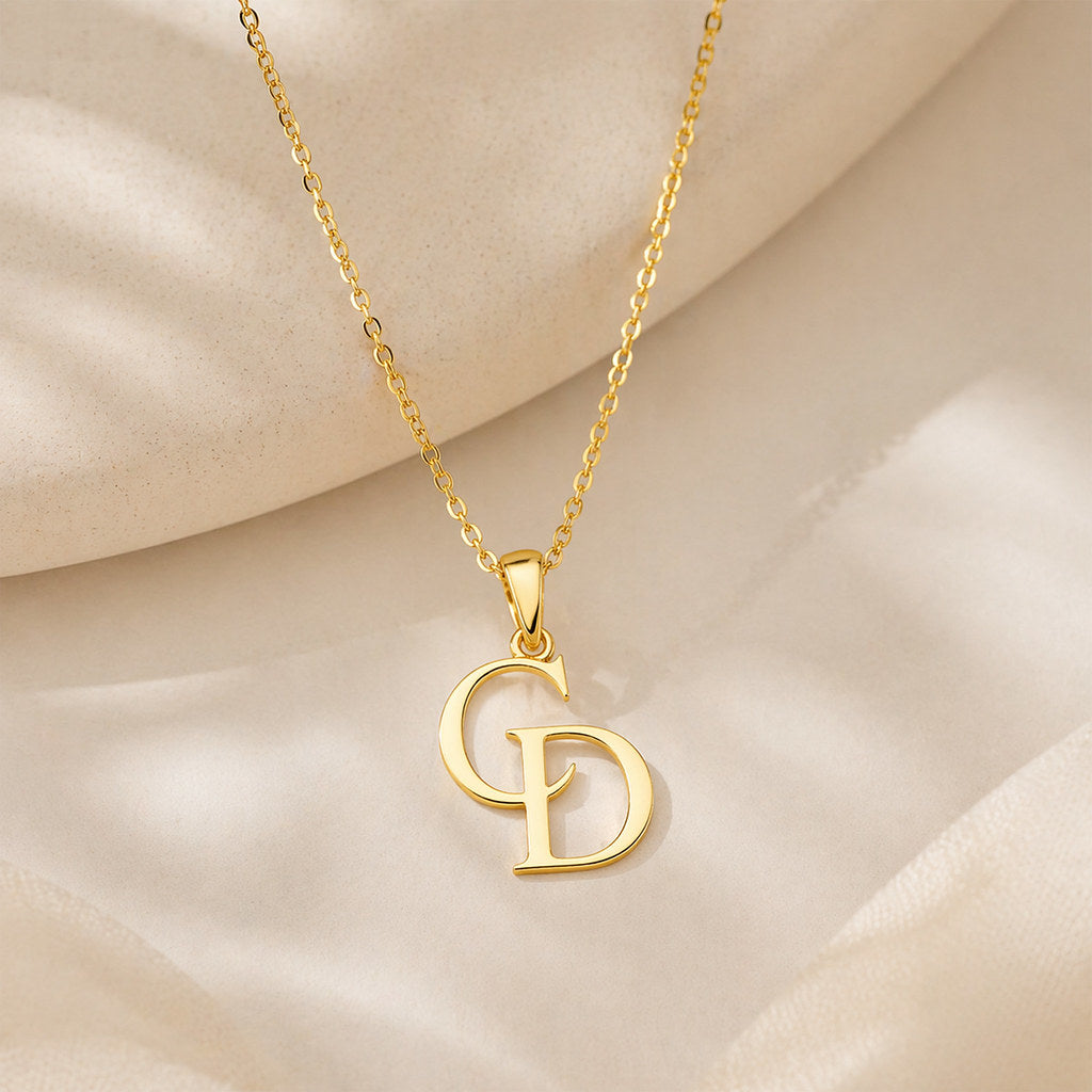 Close-up of intertwined initial pendant in gold - Calioras