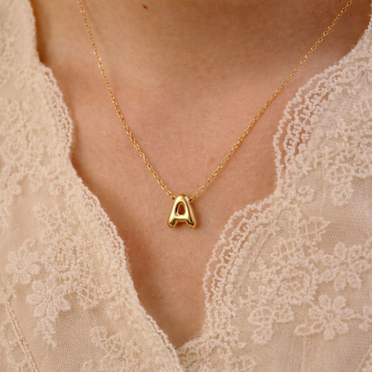 Woman wearing gold bubble letter necklace - Calioras