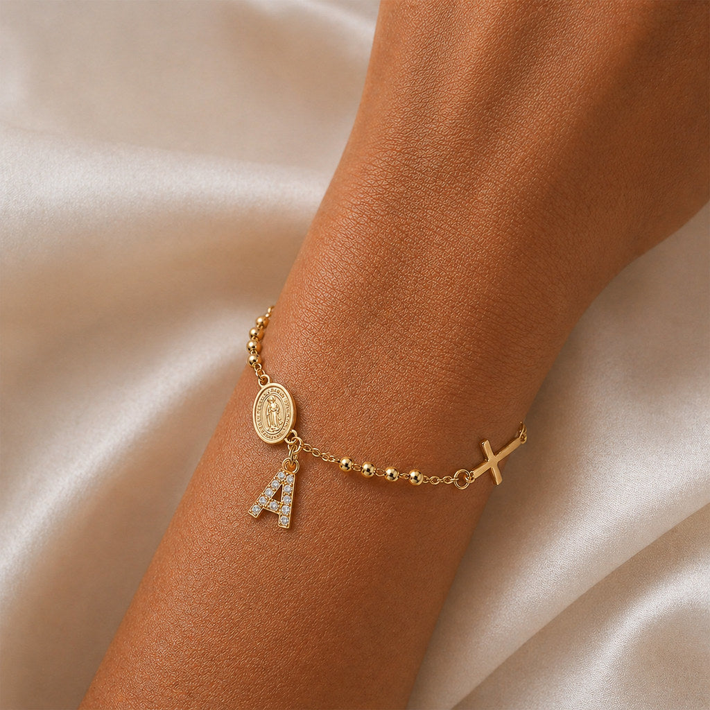 Close-up of Virgin Mary and cross charm in gold - Calioras