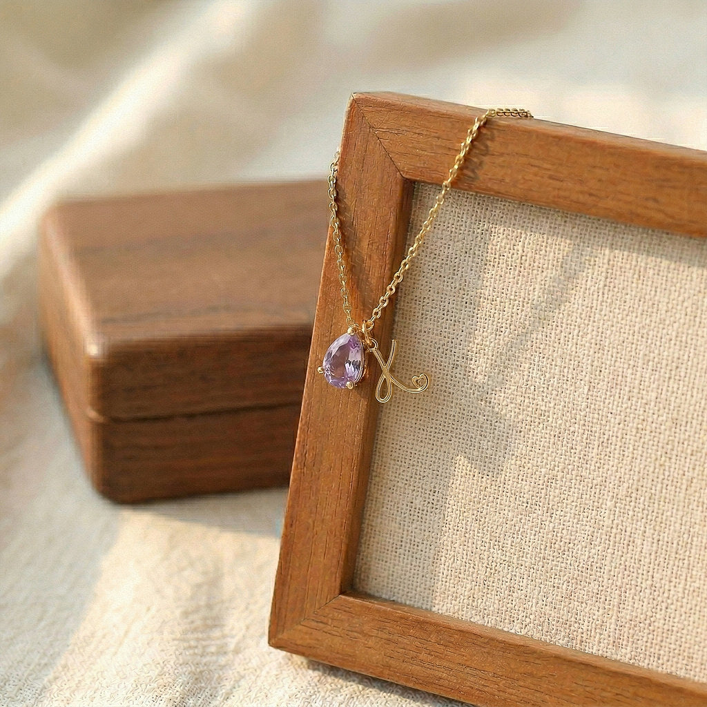 Close-up of teardrop pendant with birthstone and initial - Calioras