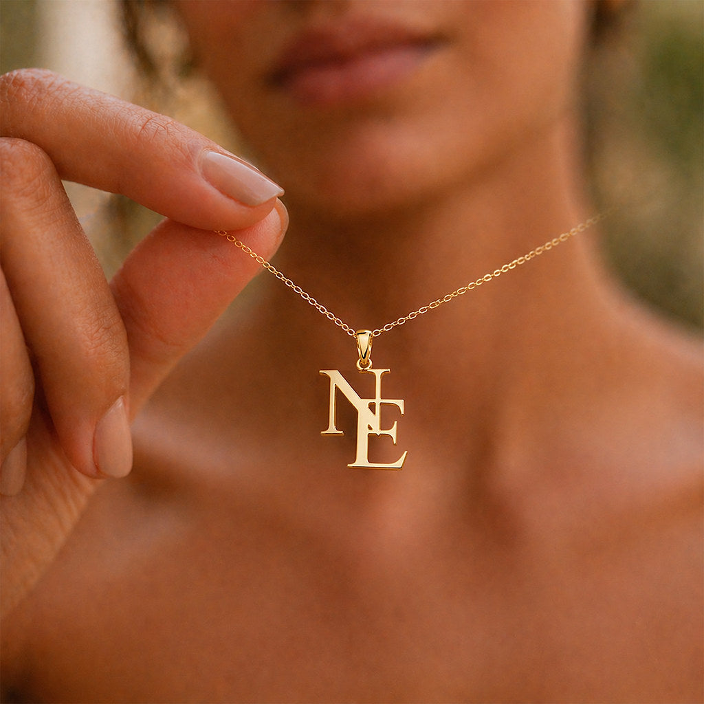 Close-up of intertwined initial pendant in gold - Calioras