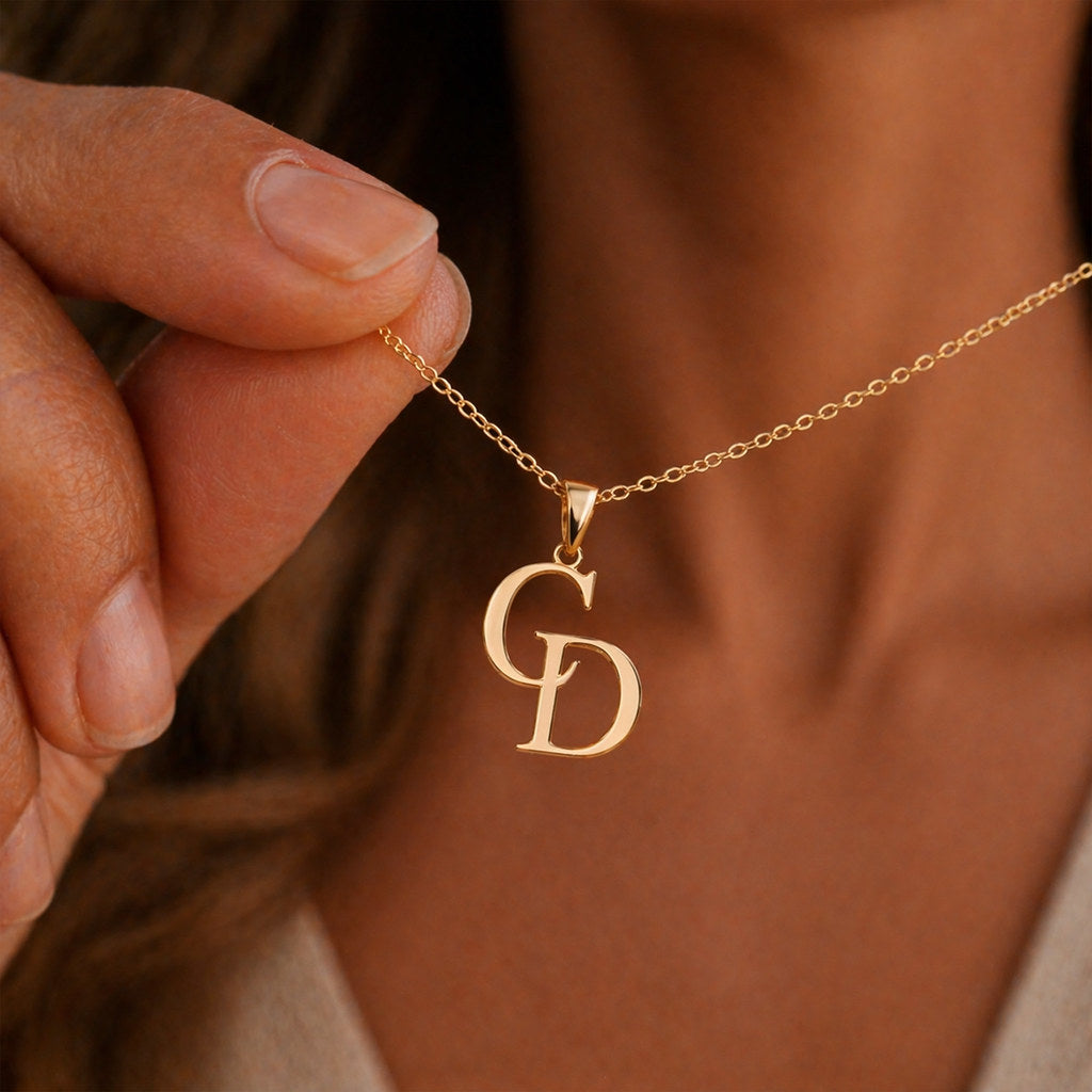 Close-up of intertwined initial pendant in gold - Calioras