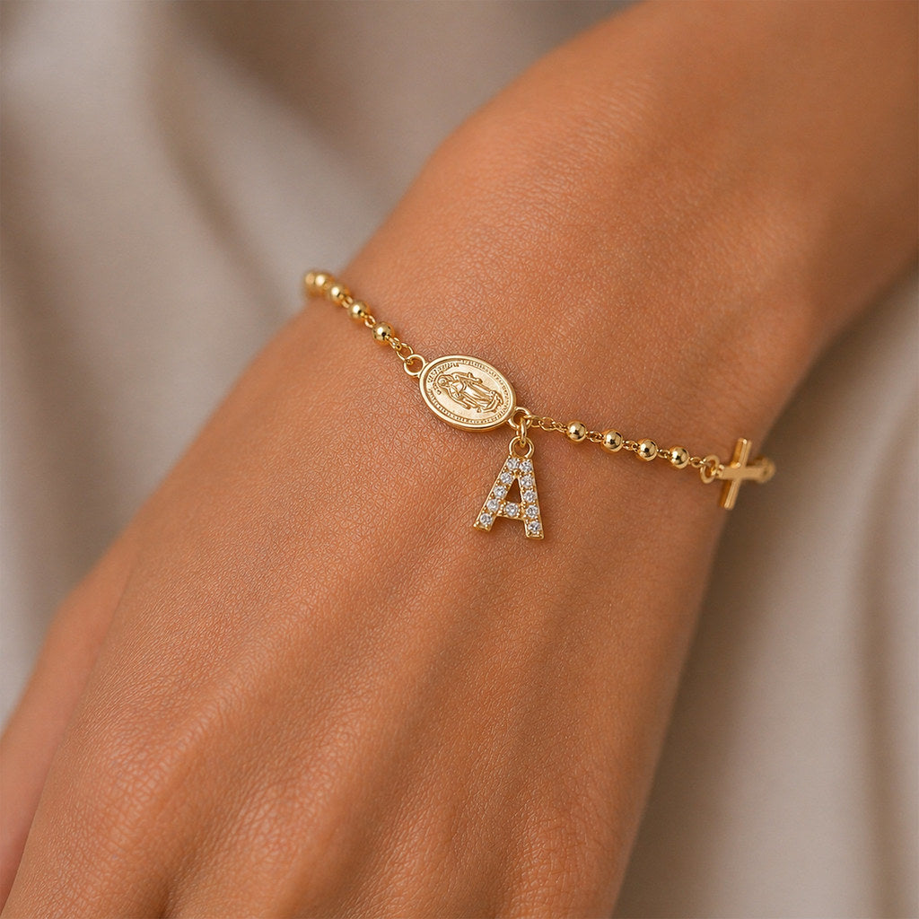Close-up of Virgin Mary and cross charm in gold - Calioras
