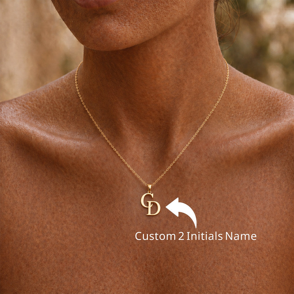 Close-up of intertwined initial pendant in gold - Calioras
