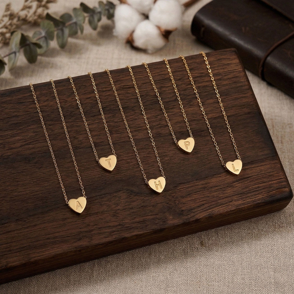 Gold necklaces with heart pendants on a wooden stand