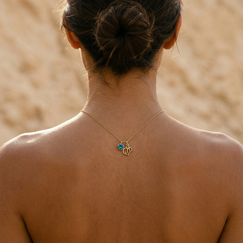 Woman wearing gold heart birthstone initial necklace - Calioras
