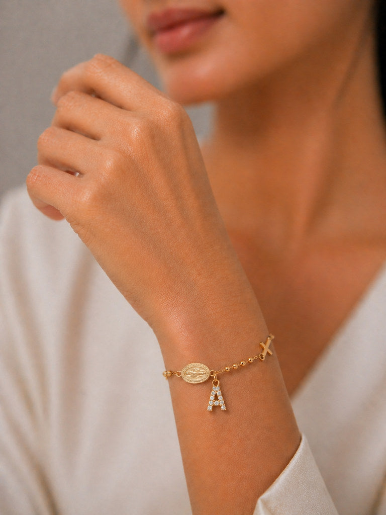 Woman wearing gold Virgin Mary cross bracelet - Calioras