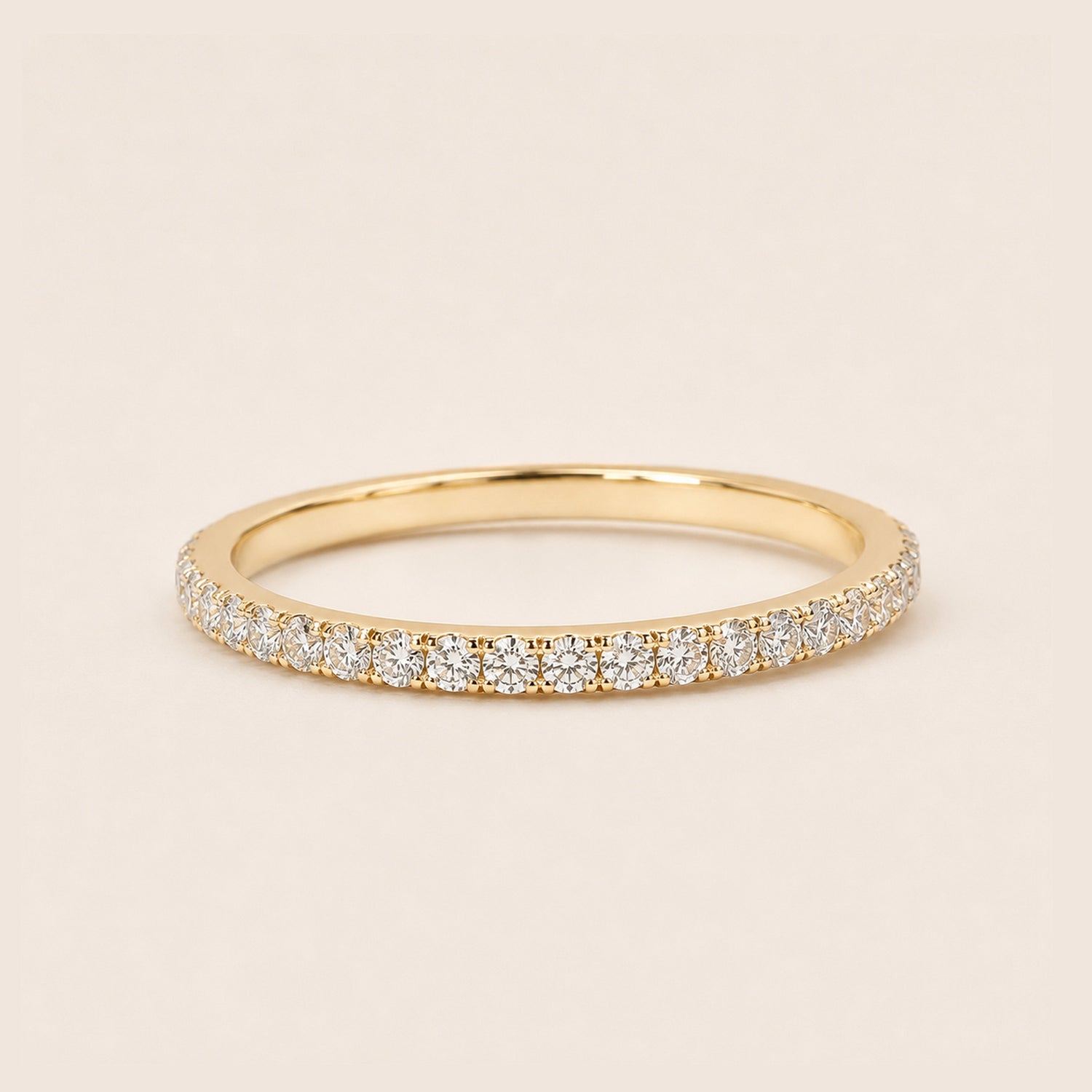 18K gold full pave CZ eternity ring dainty stackable band on cream background
