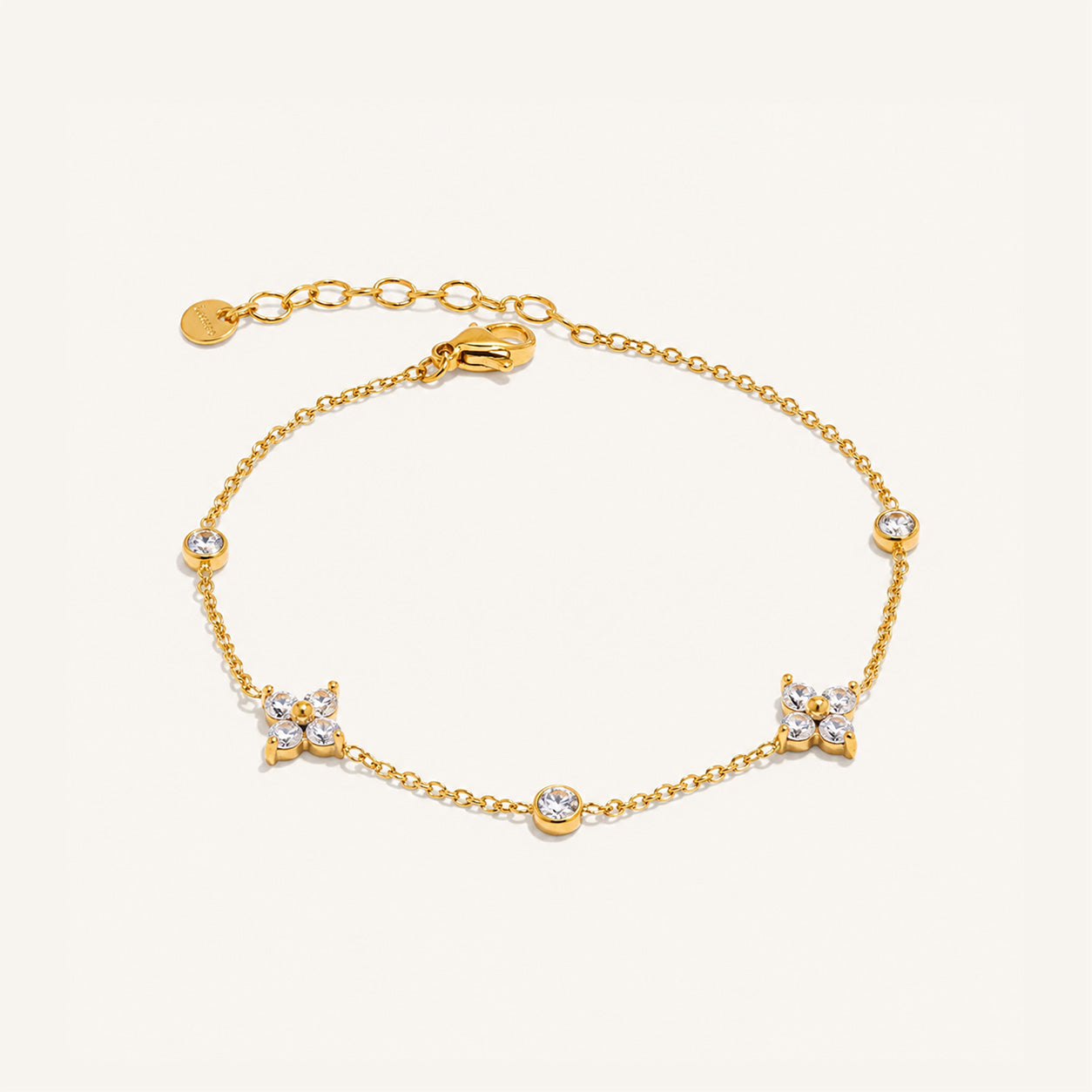 Crystal blossom station bracelet in 18K gold with CZ flowers on cream background