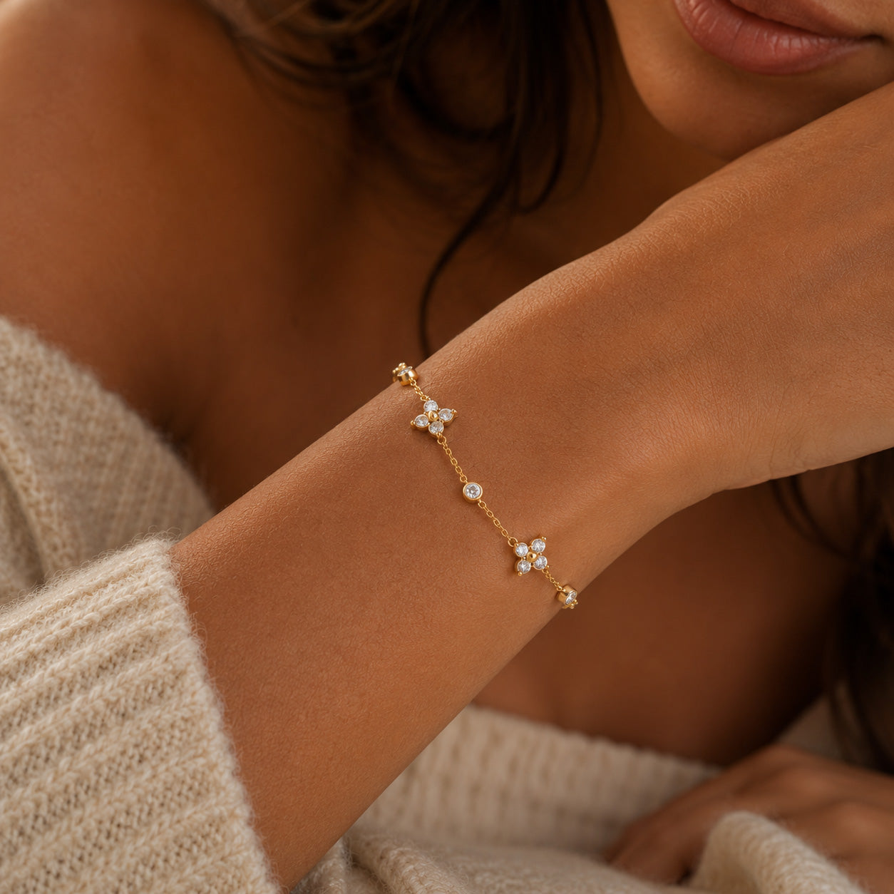 Close focus of crystal blossom station bracelet stack on wrist with model blurred behind
