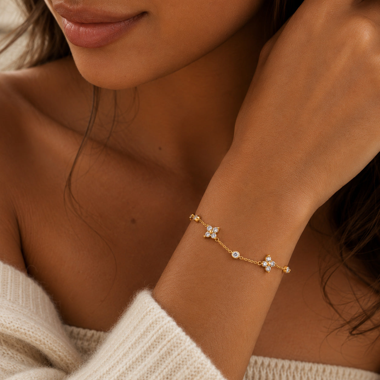 Gold crystal blossom station bracelet stacked with two Calioras bracelets on wrist