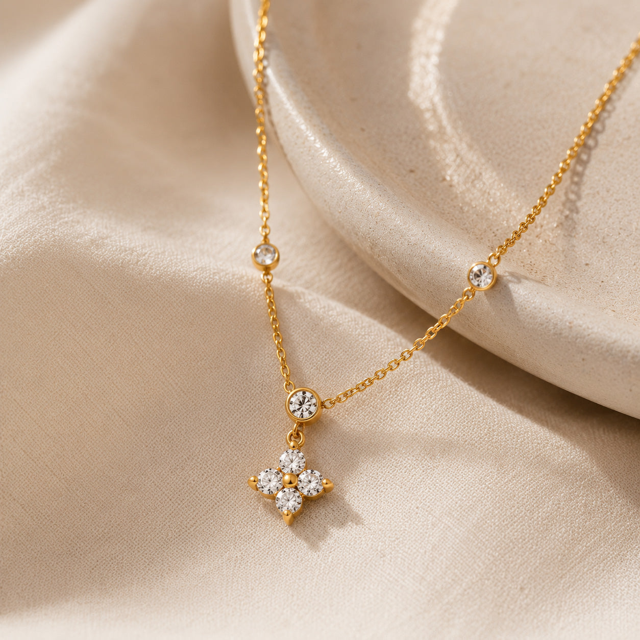 Macro detail of CZ blossom pendant and bezel-set crystal stations on cable chain