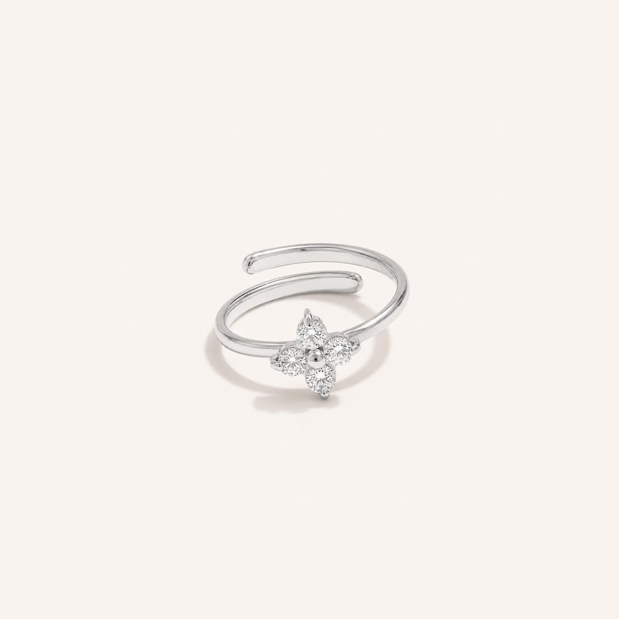 Crystal blossom ring in silver with four CZ petals on cream background