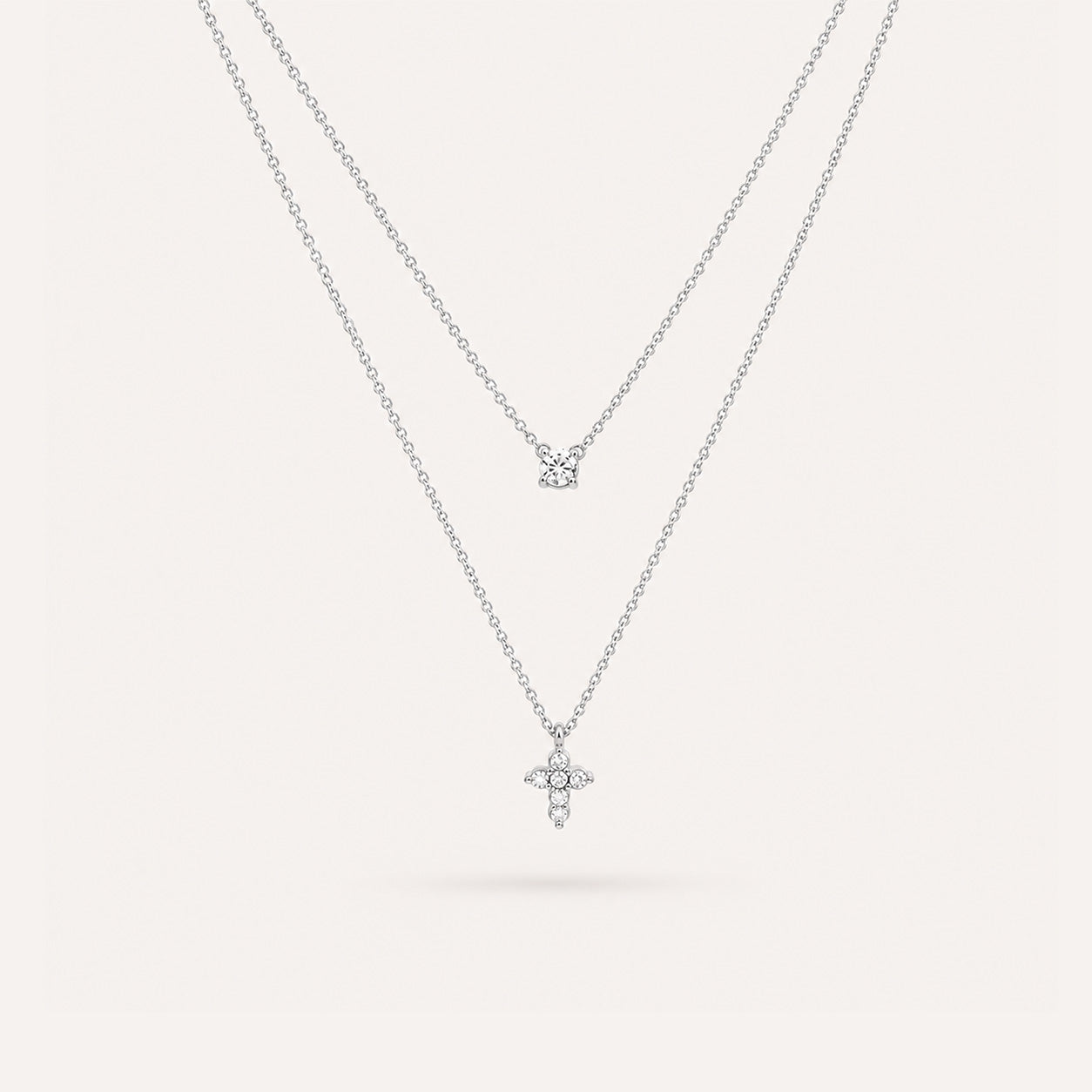Double layer mini cross necklace in silver on cream background