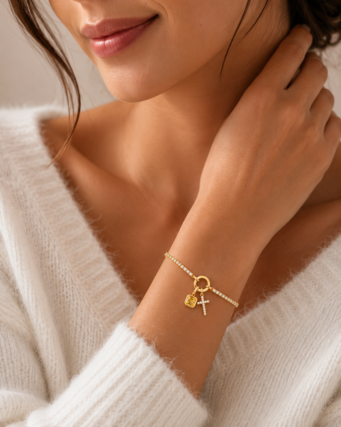 Model wearing gold tennis birthstone cross bracelet with pavé CZ cross