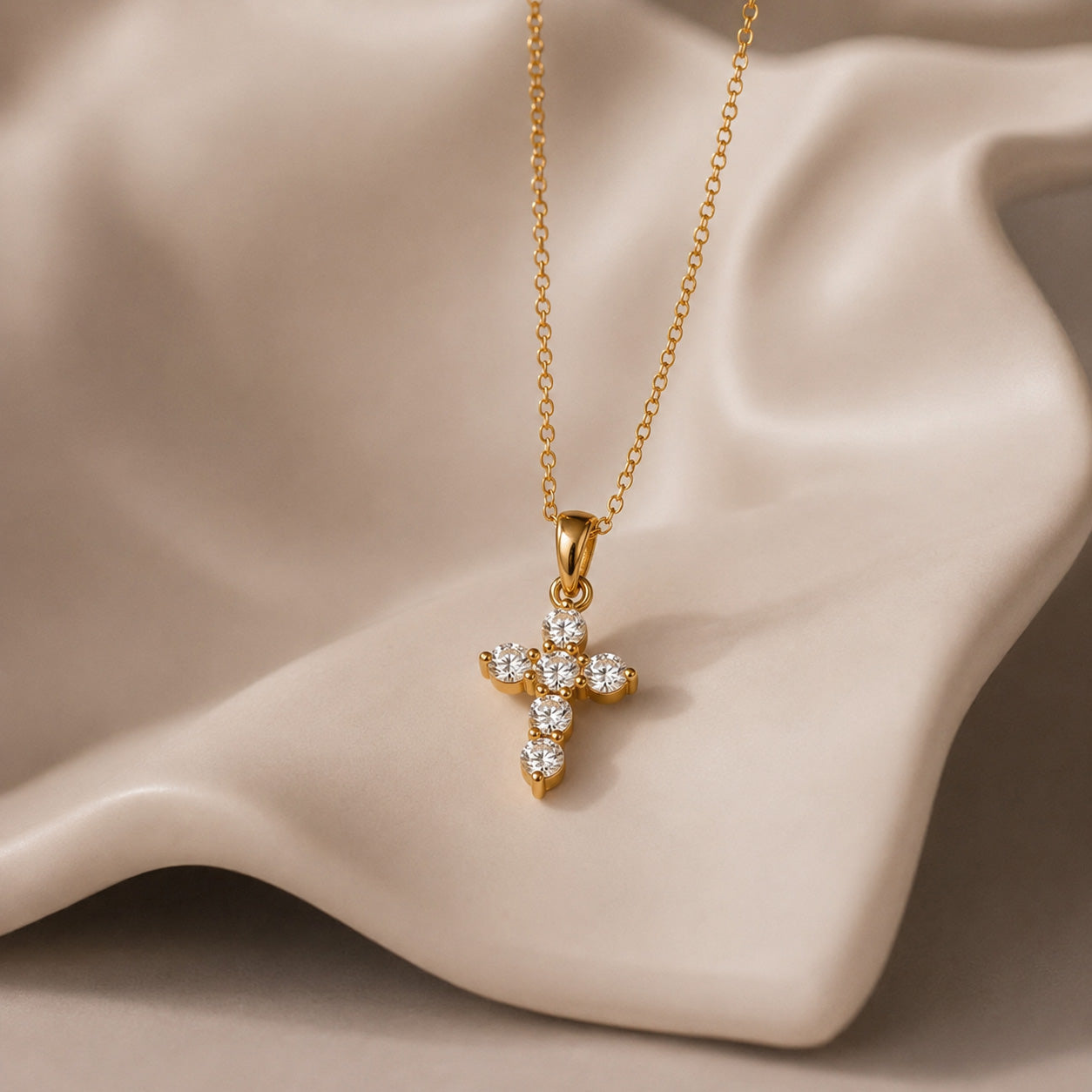 Mini crystal cross necklace draped over cream ceramic still life