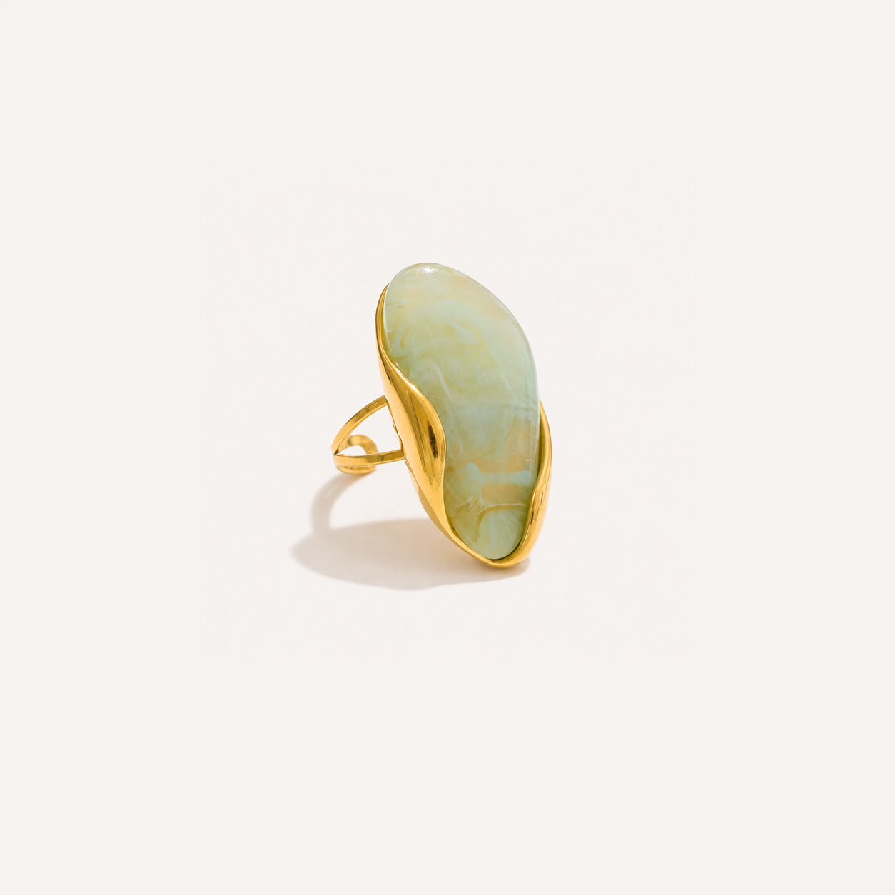 Oval stone birthstone ring in 18K gold with large oval stone on cream background