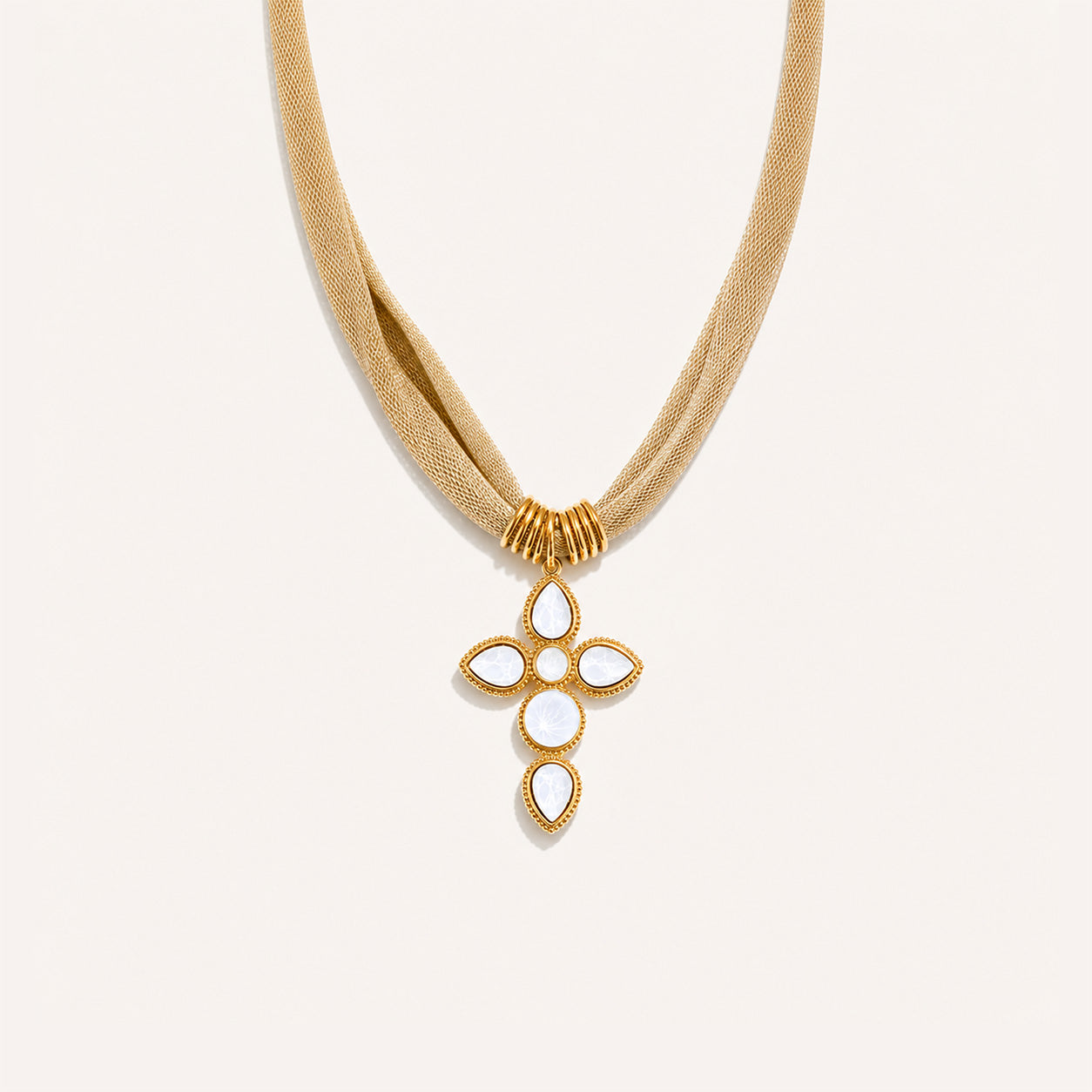 Vintage mesh cross necklace with large white crystal cross on gold on cream background